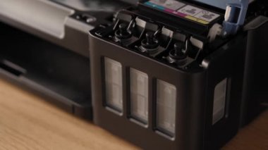 Video talimatları, teknoloji, medya, ofis, kırtasiye konsepti - erkek ellerinin yeni mürekkep püskürtme yazıcıyı fırlatmaya hazırladığı yakın plan. 9. Adım: Mürekkep dökme - tank kapağını kap ve çıkar