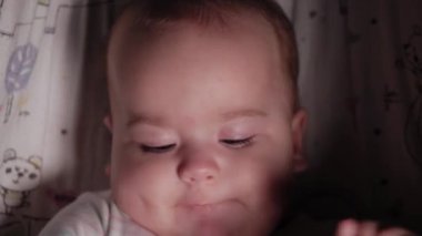 Bebek, çocukluk, duygu konsepti. Kahverengi gözlü, tombul, yeni doğmuş, uyanık, dişsiz bir bebeğin sevimli gülümseyen yüzüne yakın çekim. 7 aylık bebek kameraya bakıyor.