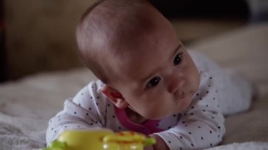 bebeklik, çocukluk, ebeveynlik, gelişim, tıp ve sağlık konsepti - önden görüş, yeni doğmuş bebek tombul bebek, pembe bedenli neşeli uyanıklık, göbeğinde çok renkli oyuncaklarla gülümsüyor