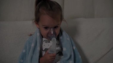 İlaç, kendi kendine tedavi konsepti. Astım sorunu olan bir çocuk yüzünde maskeyle solunum yapar ve öksürür. Hasta çocuk solunum yolu enfeksiyon solumuş bronşit. Evde zatürree nebulizatörü tedavisi.