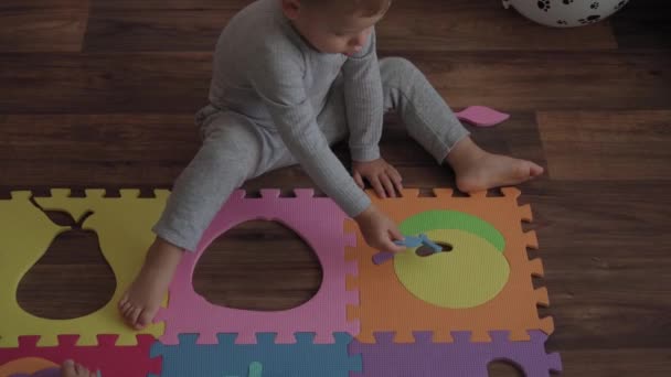 Enfance, famille, concept d'isolation - groupe deux jeunes enfants recueillent des puzzles mous fruits de grandes parties assises sur le sol. enfants Frère et sœur jouer à des jeux éducatifs pour la motricité à la maison — Video