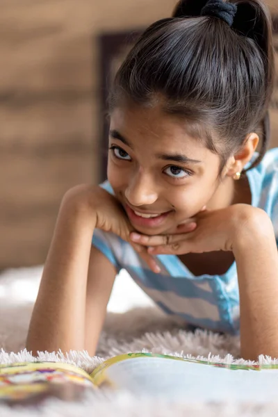 Enfance, émotions, solitude, concept de beauté portrait d'heureuse jeune fille joyeuse et joyeuse à la peau foncée de l'apparence persane du Moyen-Orient 6-9 ans souriant mignon couché sur le lit à l'intérieur. — Photo