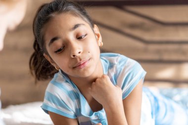 çocukluk, duygular, yalnızlık, güzellik konsepti - mutlu küçük, neşeli, neşeli, esmer tenli, orta doğu İran görünümlü 6-9 yaşlarında, kapalı bir odada sırıtan bir kızın portresi..