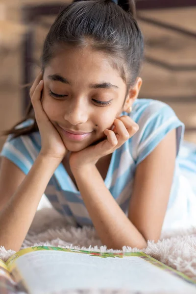 Infância, emoções, solidão, conceito de beleza - retrato de jovem feliz alegre alegre menina de pele escura alegre de aparência persa do Oriente Médio 6-9 anos sorrindo fofinho deitado na cama dentro de casa. — Fotografia de Stock