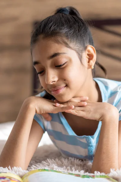 Infância, emoções, solidão, conceito de beleza - retrato de jovem feliz alegre alegre menina de pele escura alegre de aparência persa do Oriente Médio 6-9 anos sorrindo fofinho deitado na cama dentro de casa. — Fotografia de Stock