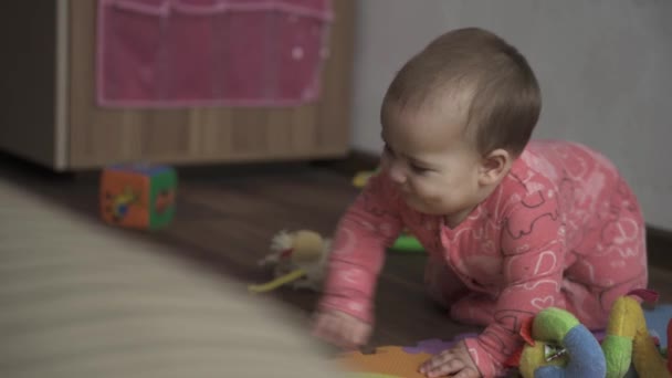 의학, 보건, 가족, 순수 한 가정, 행복 한 개념 - 행복 한 통통 한 아기가 집안에서 장난을 치고 있다. 분홍색으로 태어난 새끼들은 갈색 소파 근처에서 서 걷는 법을 배운다. 첫 단계 — 비디오