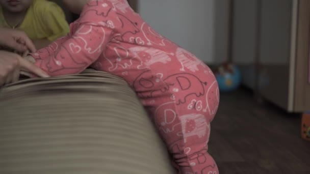Ιατρική, υγειονομική περίθαλψη, οικογένεια, αθωότητα, έννοιες ευτυχία - Ευτυχισμένο αστείο παχουλό μωρό σέρνεται παίζει στο δωμάτιο στο σπίτι. Το Joy Infant σε ροζ χρώμα μαθαίνει να περπατάει δίπλα σε καφέ καναπέ σε εσωτερικούς χώρους. Πρώτα βήματα — Αρχείο Βίντεο