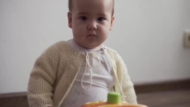 Niemowlę, koncepcja dzieciństwa - szczęśliwy zabawny maluch 8 miesięcy dziewczynka uczy się siedzieć samotnie bawić w pokoju zabaw. uśmiechnięty pulchny aktywny noworodek w białym czołgać się na kolanach podłogi w domu — Wideo stockowe