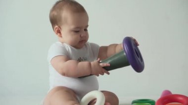 bebek, çocukluk, zihinsel beceri geliştirme konsepti mutlu komik çocuk 8 aylık bebek yalama eğitimsel mantık oyuncakları evde oyun odasında beyaz arka planda bulmaca piramidi