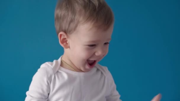 Medicina, dermatología, tratamiento, inflamación, resfriado, gripe, conceptos de cuarentena - niño menor sonriente feliz se ríe de cosquillas, juega con el médico en guantes médicos negros sobre fondo azul — Vídeos de Stock