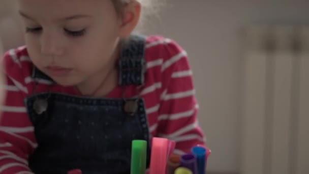 Kunst, Bildung, Kindheit, Konzepte - mit Filzstiften und Bleistiften malten kleine, fröhliche Vorschulkinder im Kleinkindalter an einem Tisch im Haus. Lächelnde Kinder malen drinnen — Stockvideo