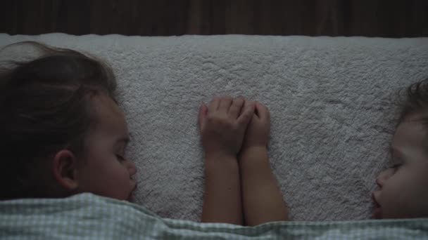リラクゼーション、甘い夢、子供時代、家族の概念-タイトアップトップビュー2人の小さな就学前の幼児の赤ちゃん兄弟姉妹ランチタイムの保育園で毛布に覆われたベッドで寝る — ストック動画