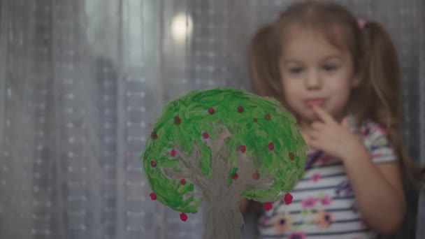 Jeugd, creativiteit, natuur, lente, zomer concept - close-up van schattig klein meisje 3-4 jaar tekenen met acryl kleuren op glas. kleuterschool kinderschilderlandschap: zon, boom, wolk, regen, bloem — Stockvideo