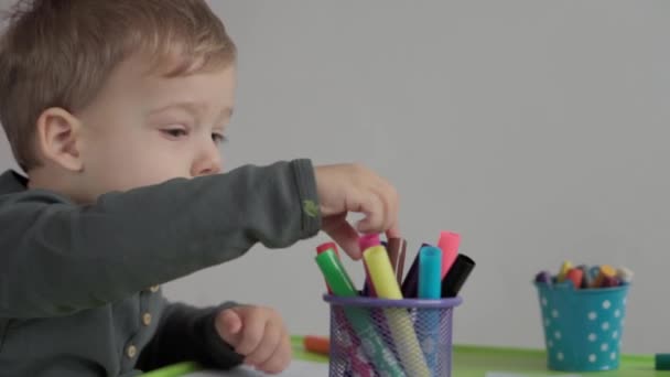 Kunst, Bildung, Kindheit, Konzepte - mit Filzstiften und Bleistiften malten kleine, fröhliche Vorschulkinder. Lächelnde Kinder Bruder Schwester malt drinnen — Stockvideo