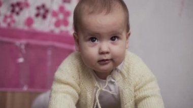 Bebek, çocukluk konsepti. Mutlu, eğlenceli, küçük bir çocuk. 8 aylık bebek, tek başına oyun odasında oynamayı öğreniyor. gülümseyen tombul aktif uyanık yeni doğmuş bembeyaz bir bebek dizlerinin üzerinde evin içinde yerde sürünüyor.
