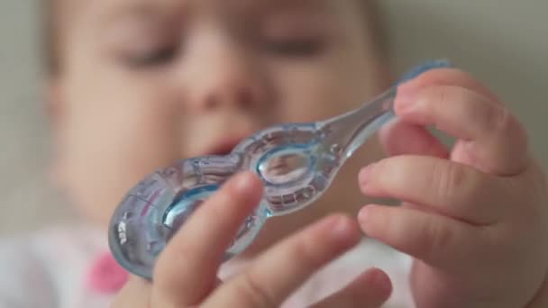 幼児、小児、衛生コンセプト-小さな子供の目を覚ますの幸せな面白いぽっちゃり顔のクローズアップ。歯のない喜び7ヶ月赤ちゃんの最初の時間は白い背景に青い歯ブラシで歯を磨く — ストック動画