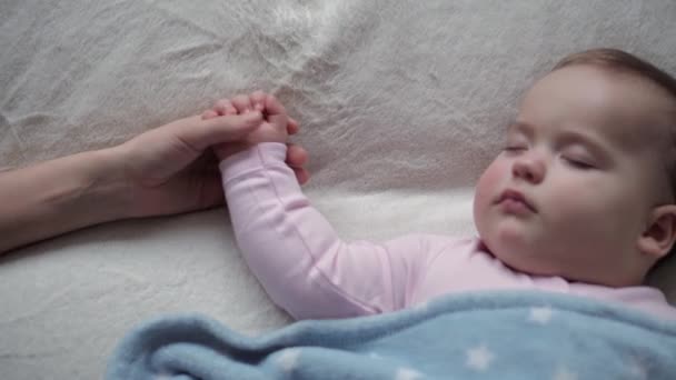 Infância, Relaxamento, Sonhos Doce, Maternidade, Conceito Familiar - mãe acariciando rosto minúsculo mão de Little 9-12 meses de idade bebê criança menina Dormir na cama branca Coberto em Cobertor no modo de sono do almoço — Vídeo de Stock