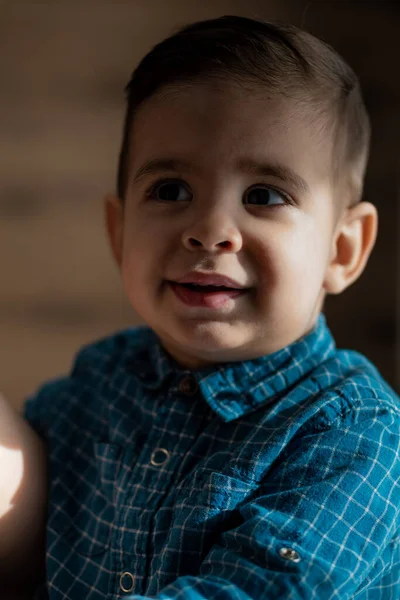 Infancia, familia, conceptos de soledad - Pequeño niño negro preescolar con ropa azul Aspecto árabe persa de dos años de nacionalidad mixta sentado en una cama de luz suave con chupete en la boca en casa — Foto de Stock