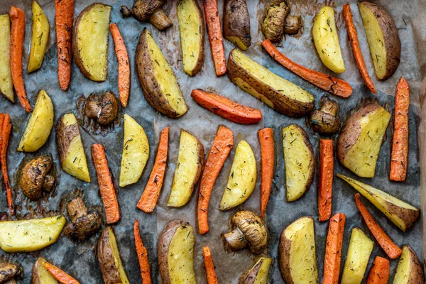 Restaurant, vegetarianism, fast, health, recipes concepts - Oven baked cut vegetables potatoes carrots, mushrooms with seasoning dill. Roasted potatoes in jackets. Top view. Close up after cooking — Stock Photo, Image