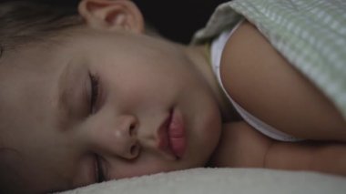 Rahatlama, Tatlı Rüyalar, Çocukluk, Aile Kavramları - Küçük 2 yaşında, anaokulunda küçük, ıslak bir çocuk, beyaz yatakta, üzerinde battaniyeyle öğle yemeği vakti uyku modunda uyur.