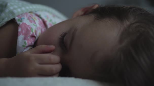 リラクゼーション、甘い夢、子供時代、家族の概念-タイトなクローズアップリトル3歳の未成年の未成年のぬれた子供の女の子ランチタイムの暗い部屋の毛布に覆われた白いベッドで寝るスリープモード — ストック動画
