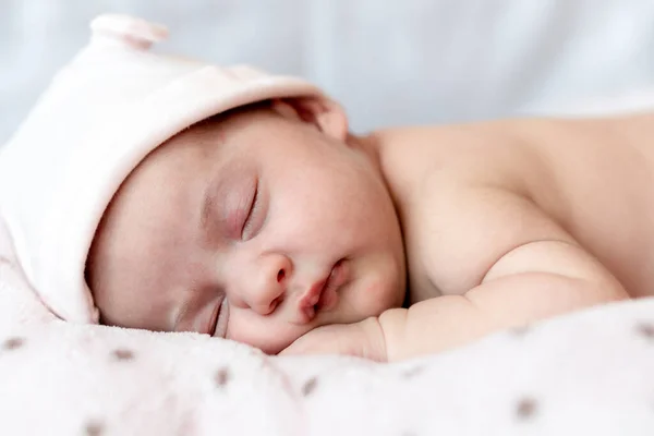 Infância, cuidados, maternidade, saúde, medicina, conceitos de pediatria - Fechar-se Um pouco de paz bebê recém-nascido menina nua e calma no chapéu rosa dorme descansar tirar o cochilo profundo deitado na barriga na cama macia. — Fotografia de Stock