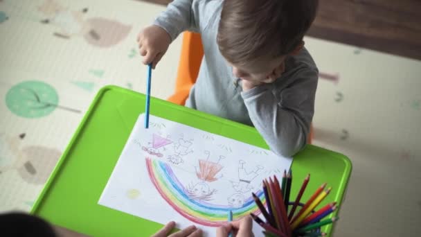 Infanzia, Arte, educazione, Creatività, concetto di mothehood - autentica giovane mamma con due bambini in età prescolare creativo ragazzo di talento 2-4 anni e neonato disegna vernici da matite immagine sedersi a tavola — Video Stock