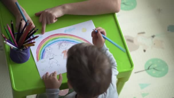 Infância, Arte, educação, Criatividade, conceito de maternidade - mãe jovem autêntica com duas crianças pré-escolar menino talentoso criativo 2-4 anos e bebê infantil desenha tintas por lápis quadro sentar à mesa — Vídeo de Stock