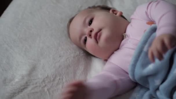 Младенчество, релаксация, сладкие сны, детство, семейная концепция - Chubby cuteLittle 9-12 месяцев Новорожденный ребенок спит на белой кровати, покрытой голубым одеялом. Девочка просыпается с растяжками. Обед — стоковое видео