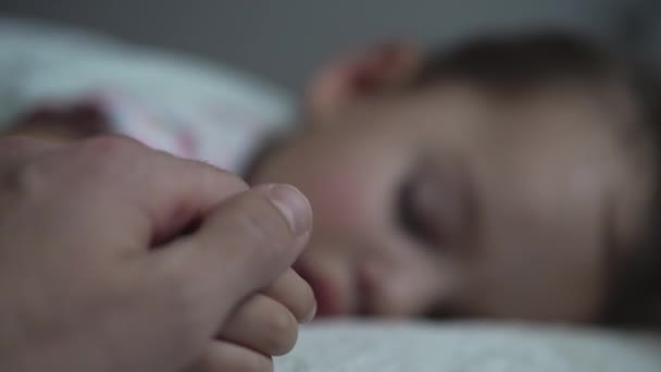 Relaxation, Sweet Dreams, Childhood, Family Concepts - Tight close up preschool toddler kid girl Sleep on Bed in Dark Room. father male hand gently strokes daughters hand face, covers with blanket — Stock Video