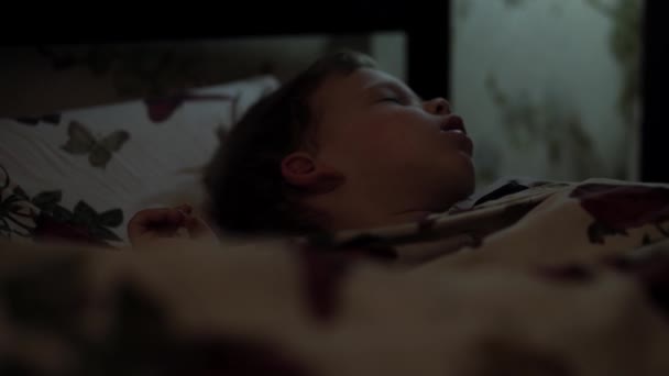リラクゼーション、甘い夢、子供時代、家族の概念-タイトなクローズアップリトル2-3歳の未成年の未成年の幼児濡れた赤ちゃん男の子は、夜の睡眠モード中にダークルームの毛布に覆われた白いベッドに横たわっています — ストック動画
