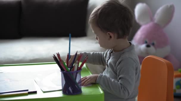 Kindheit, Kunst, Bildung, Kreativität, Mottenkiste-Konzept - authentische junge Mutter mit zwei Kindern Vorschule kreative talentierte Kind Junge 2-4 Jahre und Säugling zeichnet Farben mit Bleistiften Bild am Tisch sitzen — Stockvideo