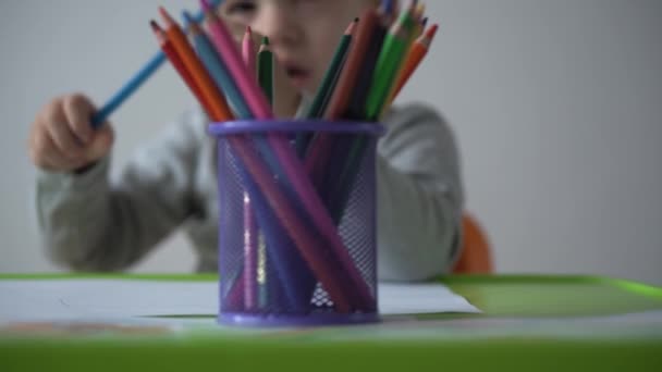 Dětství, umění, vzdělávání, kreativita koncept - autentické předškolní menší chytrý kreativní talentovaný kluk 2-4 roky kreslí barvy s barevnými tužkami obrázek rodinného jara léto, duha doma — Stock video