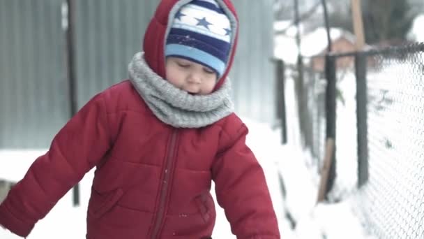 Winter, vacation, game, family concept - slow motion close up baby walk through deep snow. children feet tread on snowy path. preschool toddler kid dressed in black jumpsuit in snowfall in cold season — Stock Video