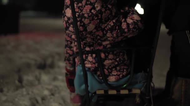 Zima, wakacje, gry, koncepcje rodzinne - autentyczne Dwoje szczęśliwych przedszkolaków rodzeństwo dzieci ubrane w kapelusze i rękawiczki z mamą bawiące się na sankach w parku w zimną pogodę w nocy na świeżym powietrzu — Wideo stockowe