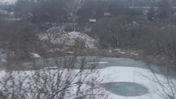 Vervoer, weg, spoorweg, landschap, hoererij, concept - uitzicht vanuit het raam van de sneltrein op het landschap van de natuur besneeuwde veld en bos tijdens de winter sneeuwstorm. reizen op het platteland per spoor — Stockvideo