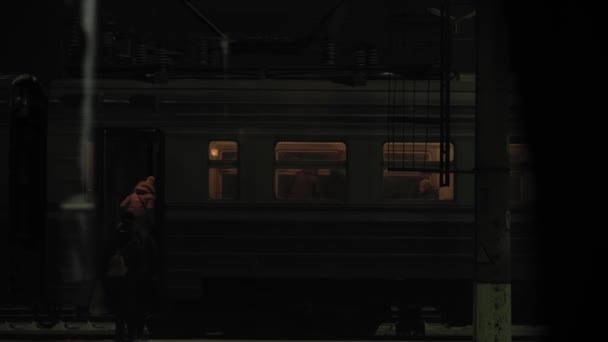 輸送、道路、鉄道、風景、通信、コンセプト-夜の夕暮れ時に鉄道駅で電車の中で搭乗人の上のウィンドウから表示されます。雪の冬に鉄道で田舎を旅し — ストック動画