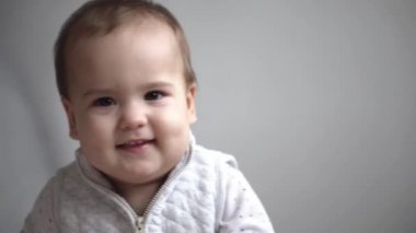 Bebek, annelik, mutluluk kavramları... Sevimli küçük bir çocuğun portresi, erkek bebek, olumlu duygulara sahip. Tatlı çocuk kameraya bakıp gülüyor. Mutlu çocukluk dişlerinin tadını çıkar.