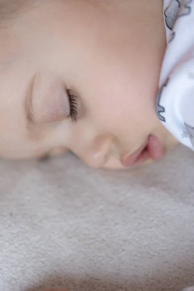 Gyermekkor, gondozás, anyaság, egészség, gyógyszer, gyermekgyógyászati fogalmak - Close up Kis béke nyugodt kisgyermek óvodás alszik pihen mély szundikálás feküdt a has puha ágyon. lefekvés előtti mod közeli szemek — Stock Fotó