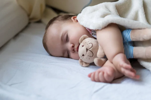 Niñez, cuidado, maternidad, conceptos de salud - Primer plano Poca paz tranquila bebé pequeño bebé niña sueño descansando tomar profunda siesta puesta abrazo peluche oso juguete en suave manta caliente con los ojos cerrados en la cama grande — Foto de Stock