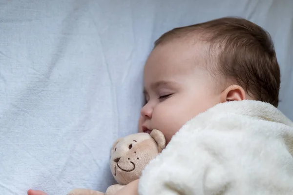 Gyermekkor, gondozás, anyaság, egészség fogalmak - Bezárás Kis béke nyugodt csecsemő kisbaba lány alvás pihenés mély szundikálás szóló ölelés maci játék puha meleg takaró szoros szemmel a nagy ágy — Stock Fotó