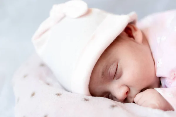 Infância, cuidado, maternidade, conceitos de saúde - Fechar-se Um pouco de paz recém-nascido menina calma no chapéu rosa dorme descansando tirar cochilo profundo que coloca na barriga no ninho de travesseiro cobertor quente macio com olhos fechados — Fotografia de Stock