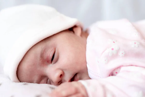 童年、照顾、母性、健康观念- -小安静静、头戴粉色帽子的女婴小憩片刻，睡在温软的毛毯枕头窝上，紧闭双眼，小睡片刻 — 图库照片