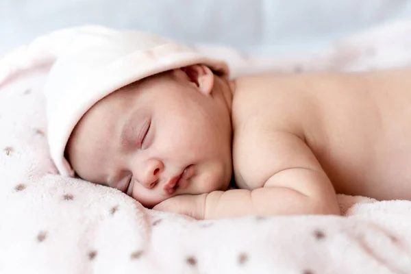 Enfance, soins, maternité, santé, médecine, pédiatrie concepts - Gros plan Petite paix calme nouveau-né nu bébé fille en chapeau rose dort au repos faire une sieste profonde posée sur le ventre sur un lit doux. — Photo