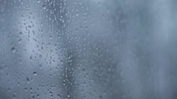 Trasporto, strada, ferrovia, paesaggio, concetto di comnicazione: le gocce ravvicinate di pioggia scendono dal vetro del finestrino del treno ad alta velocità. viaggiare per la campagna in treno. corsi d'acqua correnti di fondo — Video Stock