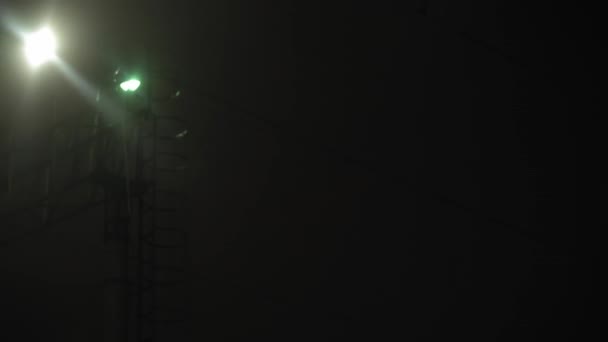 Transporte, carretera, ferrocarril, paisaje, comunicación, concepto - vista desde la ventana del tren de velocidad en paneo tiro de mano no estabilizado de nevadas. Caída de copos de nieve en la luz amarilla de las farolas — Vídeos de Stock