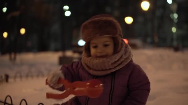 Inverno, férias, jogos, conceitos de família - plano do meio de autênticos pequenos irmãos pré-escolares felizes Crianças se divertem no parque da noite, esculpir bolas de neve cair na área de neve em tempo gelado frio — Vídeo de Stock