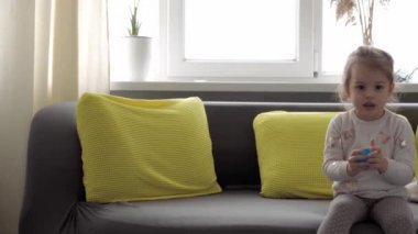 Mavi ve kırmızı sümüklü otantik bebek elleri. Kız ve oğlan anaokulunda yan yana oyun hamuru esnetiyorlar. Çocuk plastikçilik oynuyor. Modaya uygun sıvı oyuncak sarı kanepede el ve parmaklara yapışıyor.