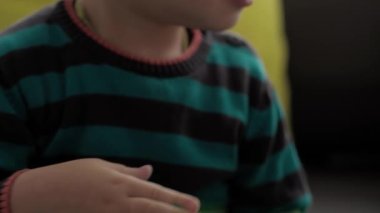 Mavi ve kırmızı sümüklü eller, yaklaşın. Kız ve oğlan anaokulunda yan yana oyun hamuru esnetiyorlar. Çocuklar plastik hamur oynuyorlar. Modaya uygun sıvı oyuncak sarı kanepede el ve parmaklara yapışıyor.