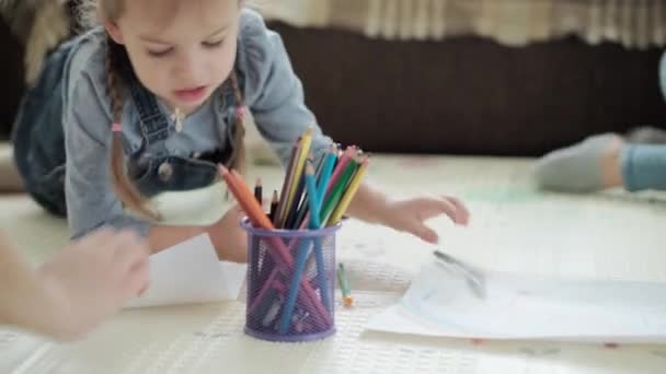 Autentické dva šťastné sourozenecké batole kreativní děti s maminkou kreslit tužkami jaro přichází obraz duha bavte se na podlaze uvnitř v herně. Dětství, umění, vzdělávání, tvořivost, koncepce mateřství — Stock video